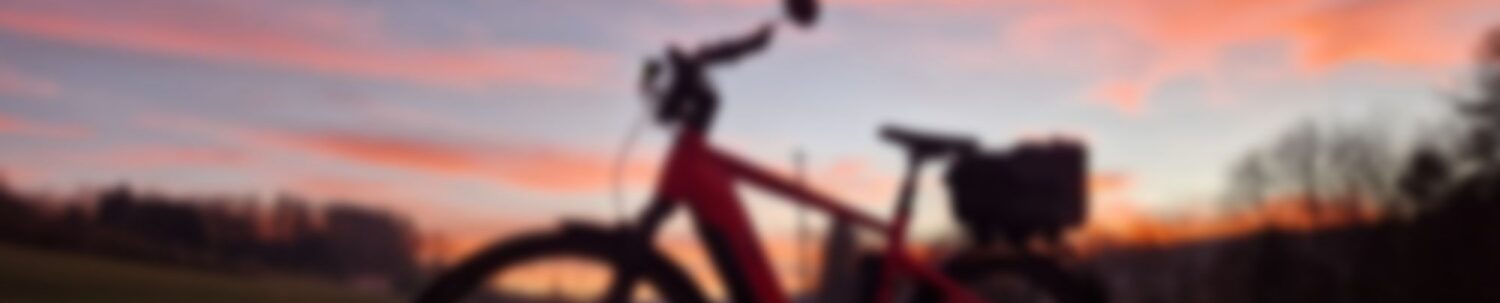Ein leicht unscharf gemachtes Bild von einem Fahrrad vor einem Sonnenuntergang